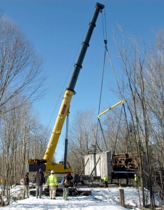 The 1918 historic Snyder Brook Pony Howe Truss Bridge was lifted from its cut stone abutments, the east partially broken apart, on Friday, Dec. 5 by operator John Lavoie of Littleton of CCS Crane Service of Morrisville, Vt., and then placed on a dirt platform on the north side of Presidential Recreational Rail Trail in Randolph. The dilapidated abutment and bridge will be repaired, and the bridge put back in place in summer 2015. Photo taken from east (Gorham) side of brook; crane is on west (Jefferson) side.